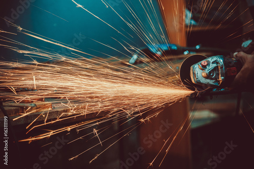 Sparks during cutting of metal angle grinder. Close-up saw sawing a steel