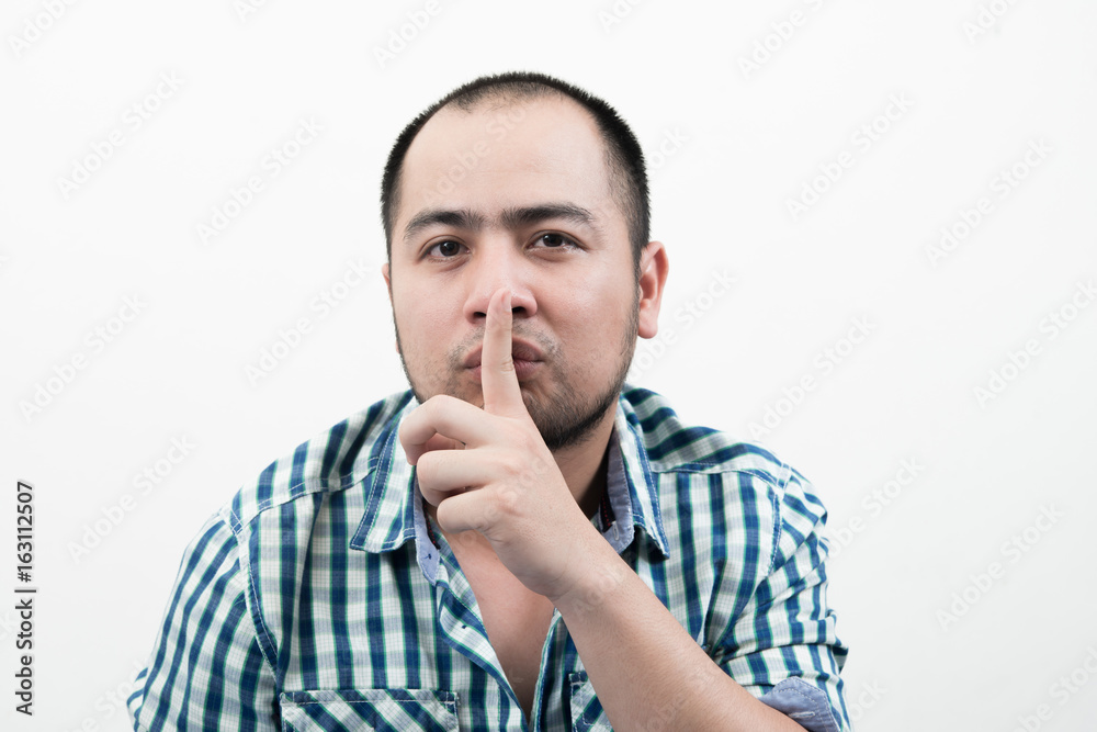 Young man making silence gesture isolated on white background. Young man making silence gesture isolated on white background.