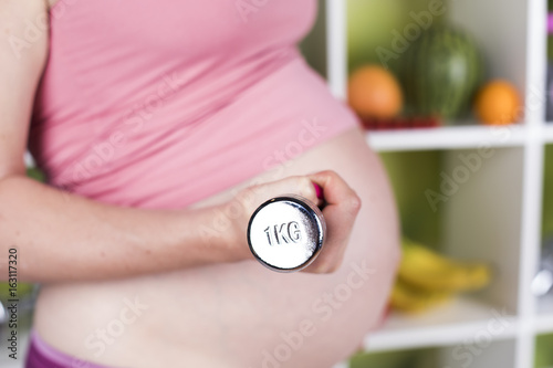 Fototapeta Naklejka Na Ścianę i Meble -  Nutrition and diet during pregnancy, fruits and vegetables and dumbbell