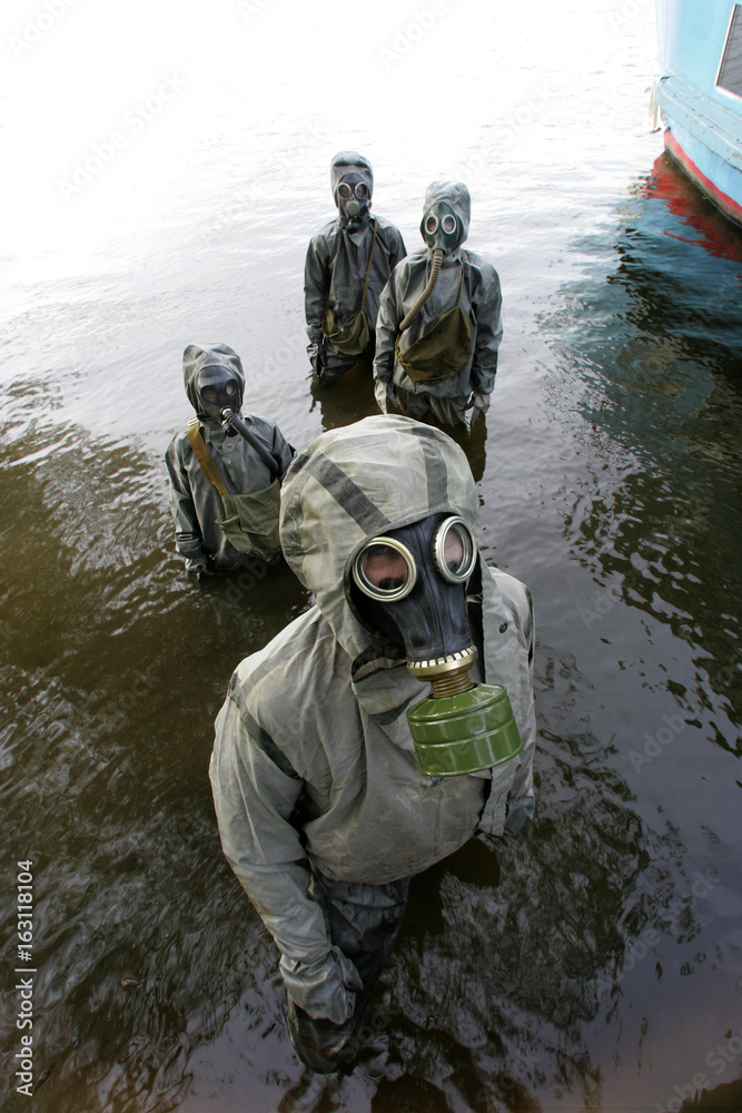 People wearing gas masks and protective suits in civil defense classes People wearing gas masks and protective suits in civil defense classes