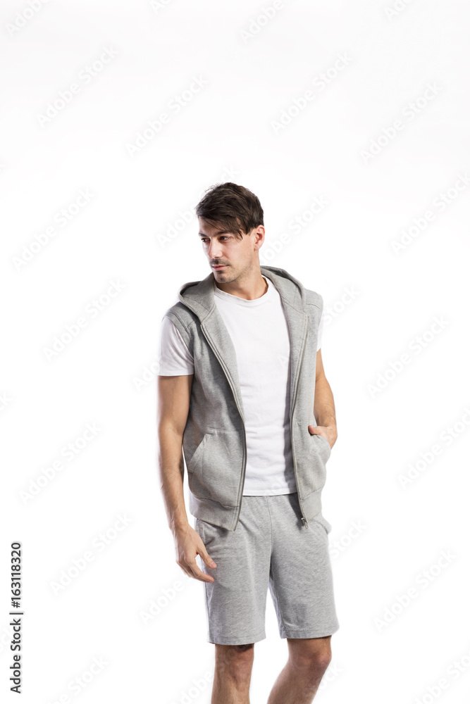 Handsome fitness man in vest with hood, studio shot. Handsome fitness man in vest with hood, studio shot.