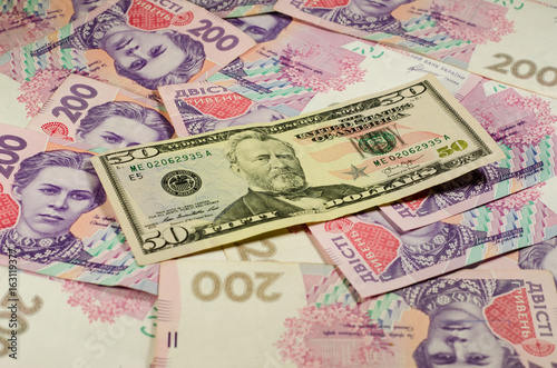 Fifty dollars banknote on the background of ukrainian hryvnas
