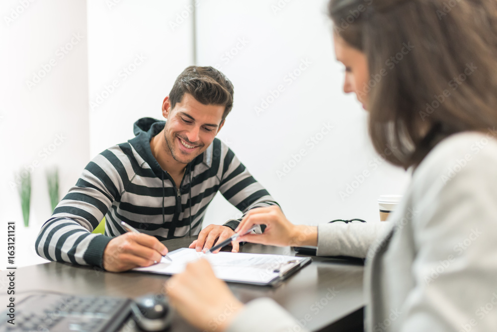 Man signing paper in office