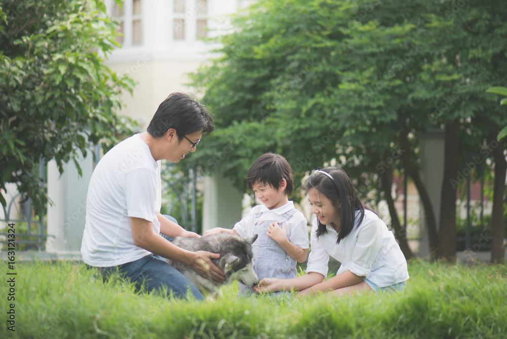 Happy Asian family playing with siberian husky dog Happy Asian family playing with siberian husky dog