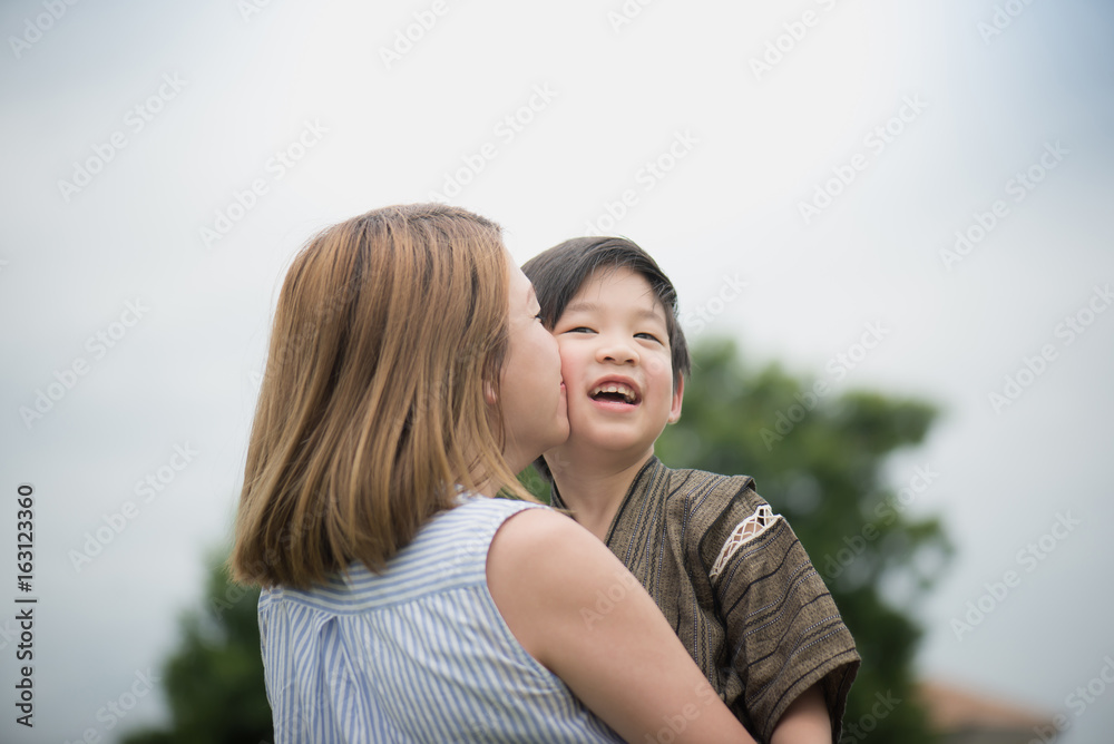 Asian mother and her son playing in the park Asian mother and her son playing in the park