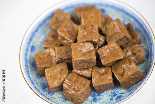 Traditional Asian cuisine-dried tofu(simmered bean curd) on Ceramic Plate on a white background.