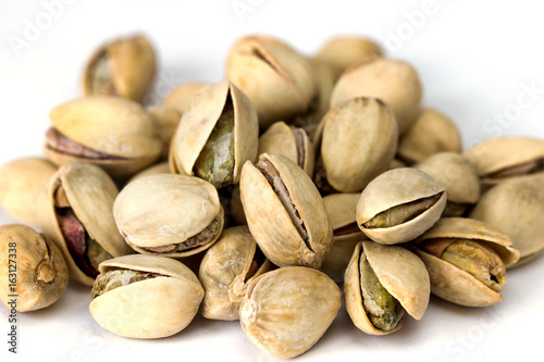 Heap of pistachio nuts isolated on white background close up photo