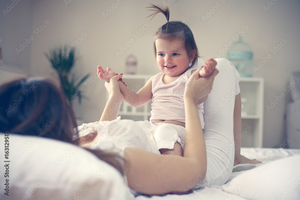 Fototapeta premium Mother and baby playing in the bed.