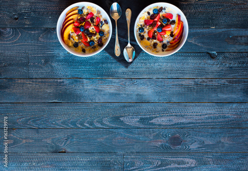 Healthy breakfast with milk,muesli and fruit, on a wooden background.