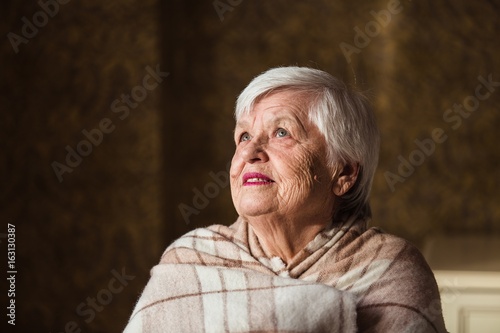 Portrait of an old woman are bundled up in blanket