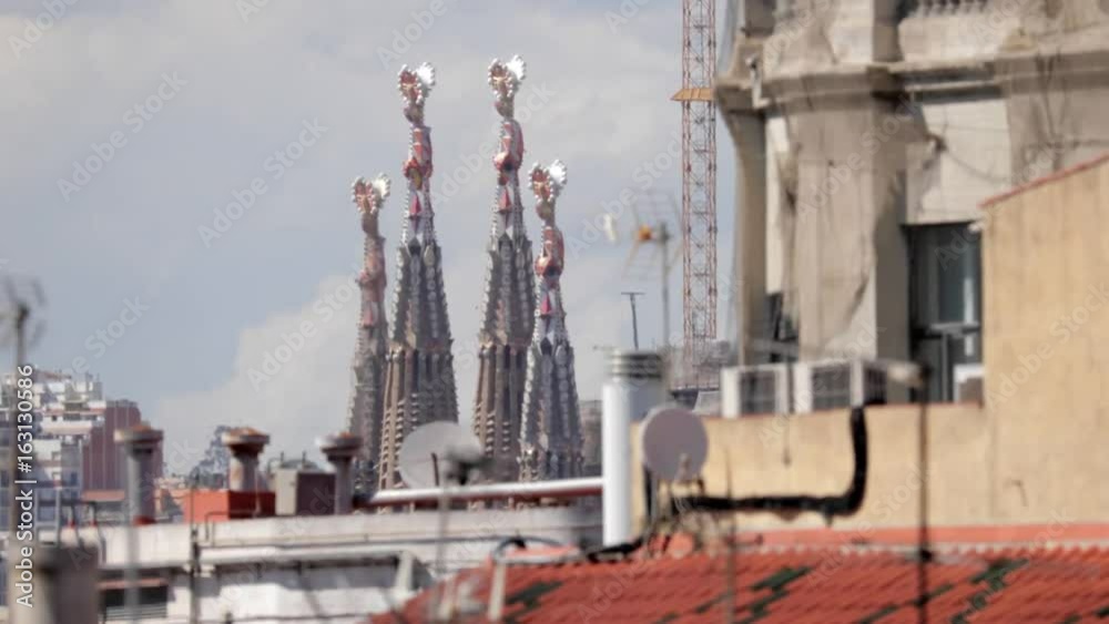 extreme zoom of sagrada familiar in barcelona shot from a terrace in the centre of the city. 