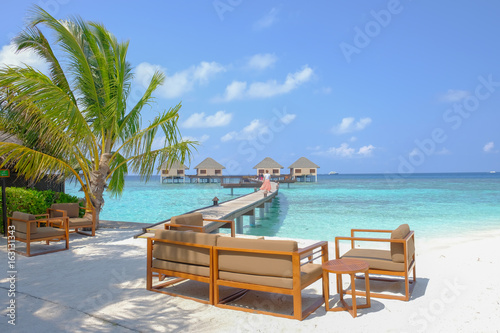 Enjoy  have a seat and relax in the water bungalows deck at the summer days. Maldive Islands.
