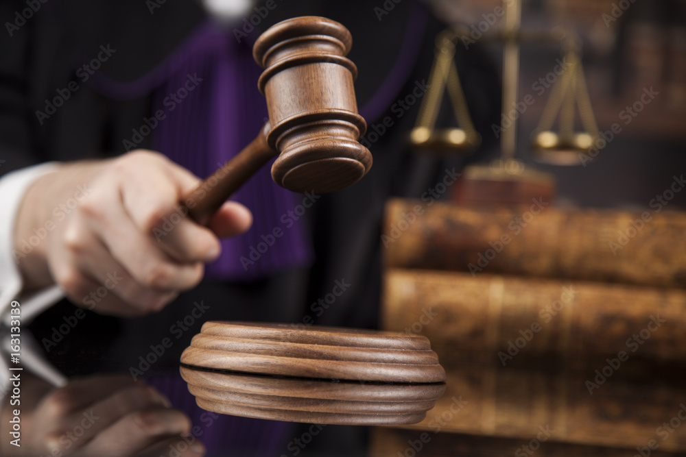 Judge, male judge in a courtroom striking the gavel Judge, male judge in a courtroom striking the gavel