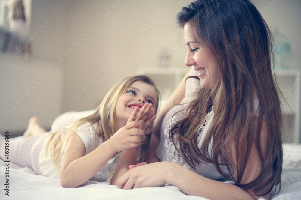 Mother with her cute little daughter on bed. Mother with her cute little daughter on bed.