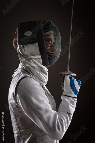 Woman fencer with Mask holding the sword in front of her