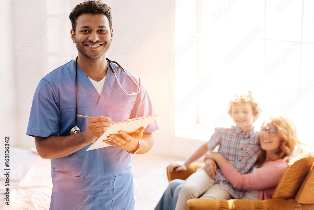 © zinkevych - Positive delighted dark-skinned doctor that posing on camera