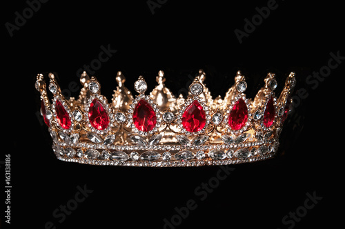 Red crown with red gems isolated on black background