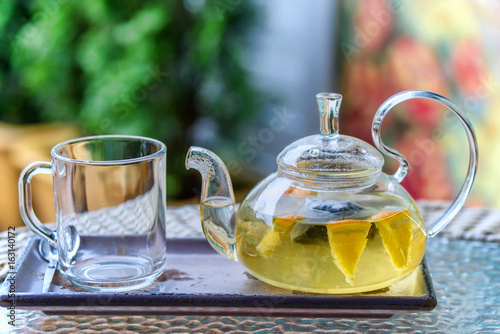 Fresh lemon tea in glass transparent teapot
