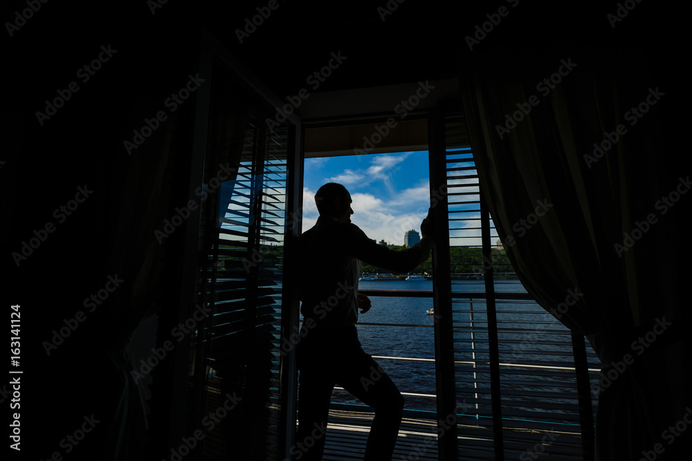 Profile of a man by the window overlooking the sea