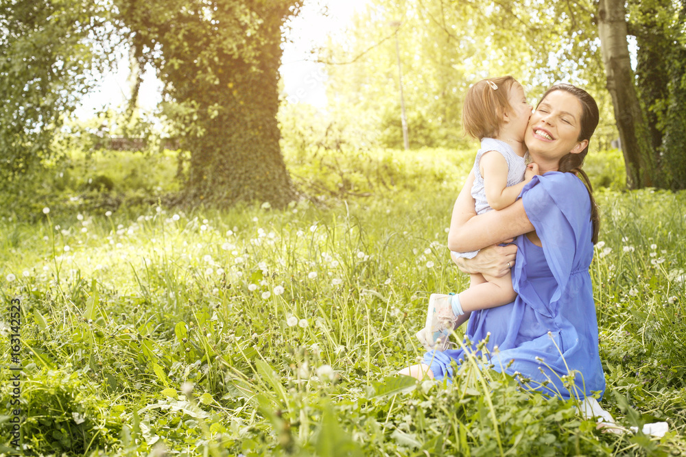 Pregnant mother playing with little daughter in park. Pregnant mother playing with little daughter in park.