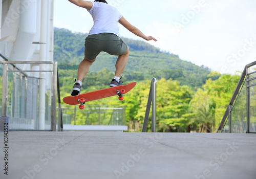 young woman skateboarder skateboarding at city