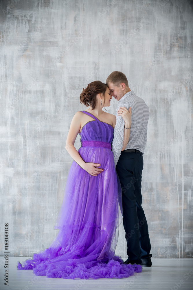 pregnant woman and man posing together in the Studio