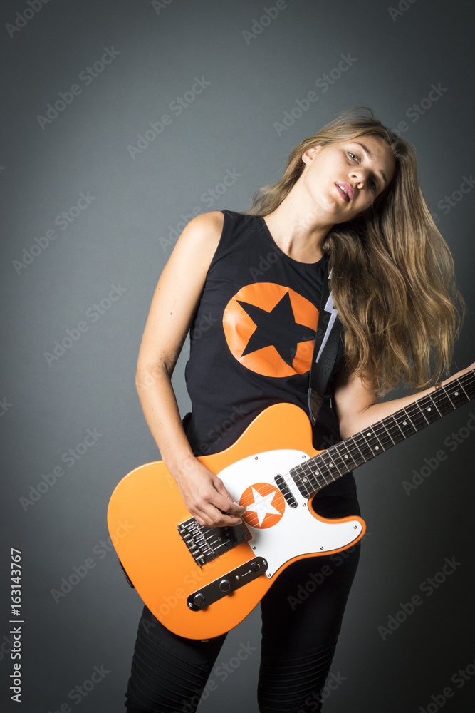 Fototapeta premium Model playing guitar and posing on stage