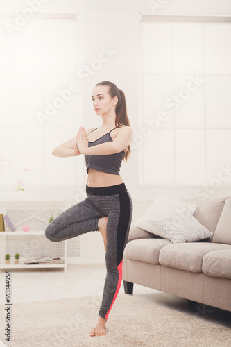 Woman yoga stretching at home, tree pose