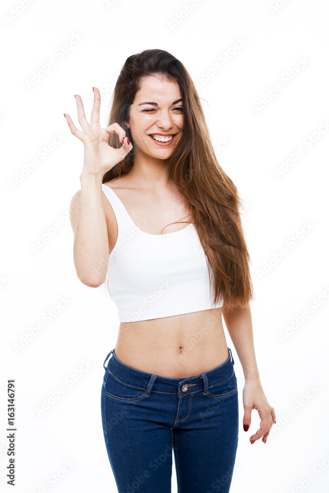 Beautiful young woman making OK sign over white background. Beautiful young woman making OK sign over white background.