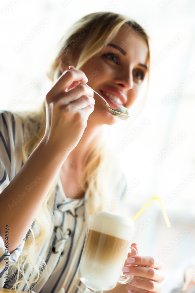 selective focus of smiling woman holding teaspoon with coffee cream selective focus of smiling woman holding teaspoon with coffee cream