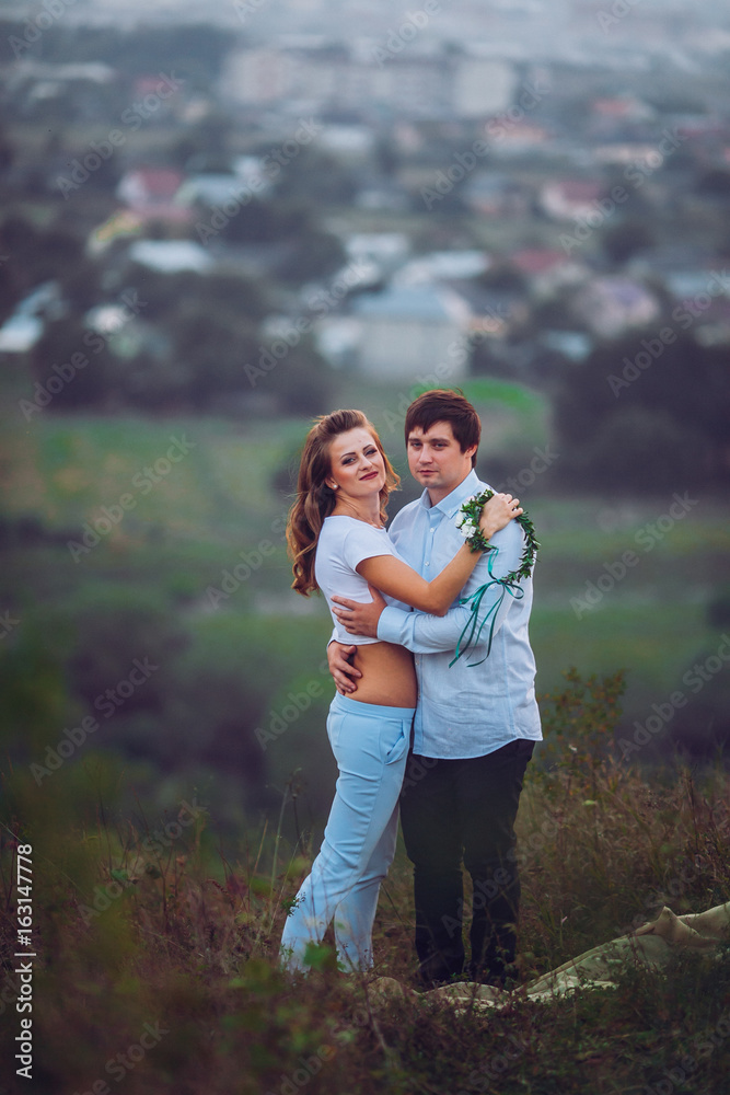 Romantic couple at sunset on bright yellow sky and city background, love tenderness concept, young adult people Romantic couple at sunset on bright yellow sky and city background, love tenderness concept, young adult people