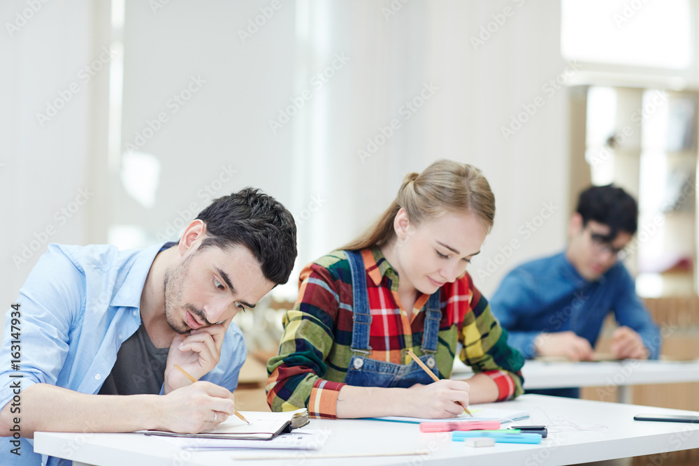 Guy talking by mobile phone while sitting at lesson Guy talking by mobile phone while sitting at lesson