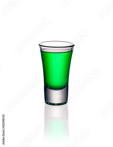 Glass shot with green absinthe isolated