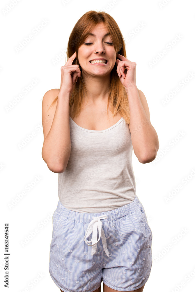 Beautiful girl in pajamas covering her ears Beautiful girl in pajamas covering her ears