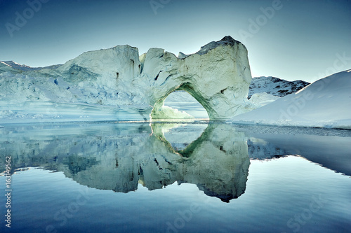iceberg floating in greenland fjord photo