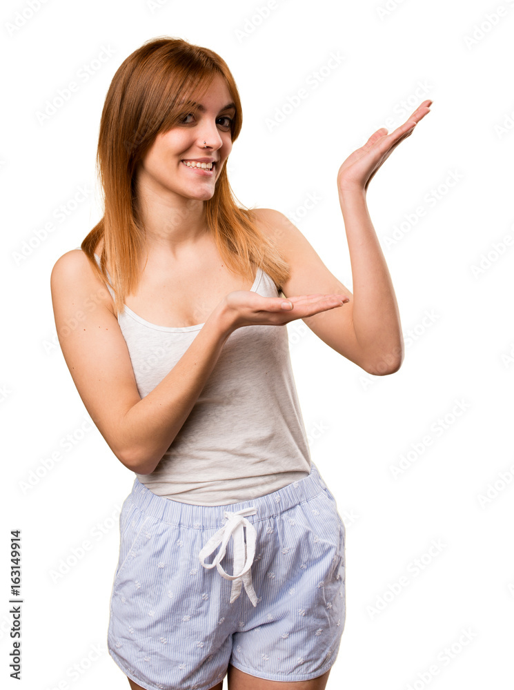 Beautiful girl in pajamas presenting something Beautiful girl in pajamas presenting something