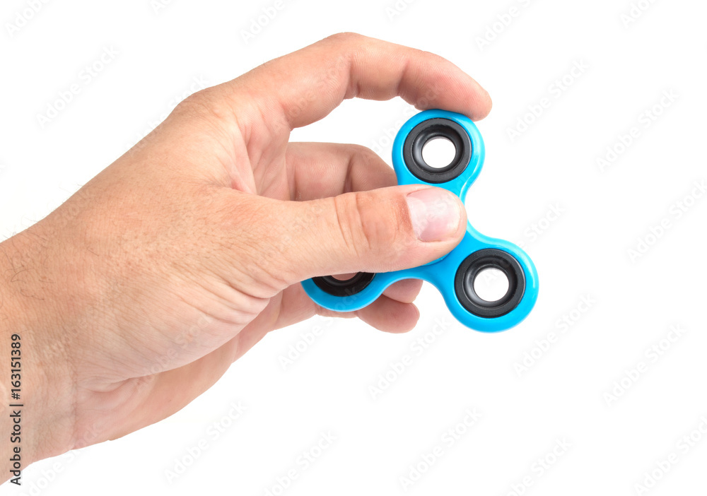 Hands of child twist blue spinner stress relieving toy isolated on white background Hands of child twist blue spinner stress relieving toy isolated on white background