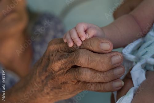 old people and a baby holding hands 