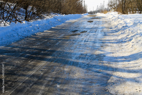 Rural frozen slippery asphalt road on winter