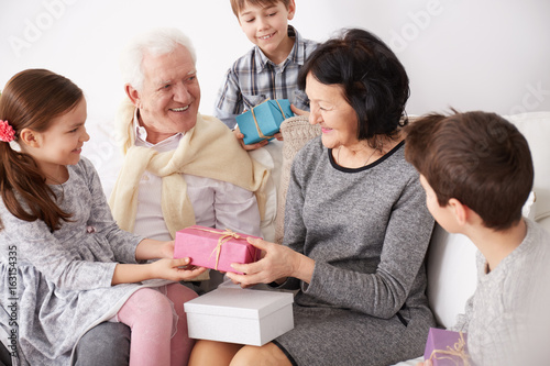 Grandchildren giving presents to grandparents © Photographee.eu