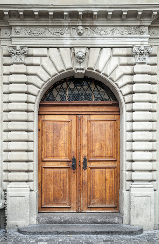 Old wooden door in gray stone wall