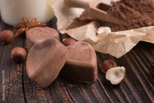 Chocolate heart-shaped candy on a rustic background, chocolate composition