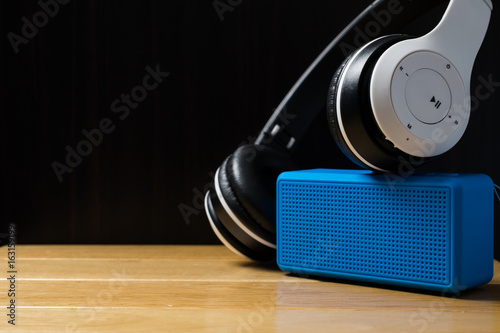 headphones and blue speaker on the table