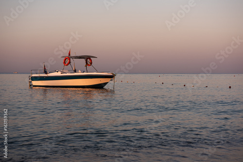 Boat on Mediterranean sea at dawn.