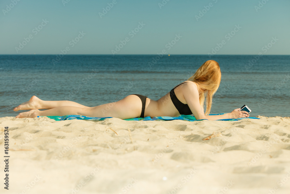 Woman in bikini sunbathing and relaxing on beach Woman in bikini sunbathing and relaxing on beach
