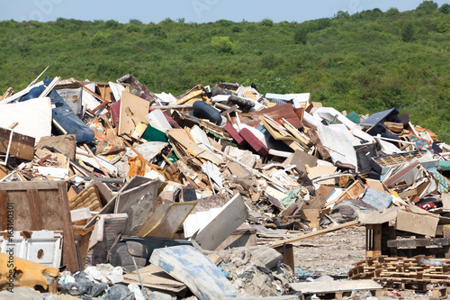 Old furniture at the landfill in focus, nature in the background