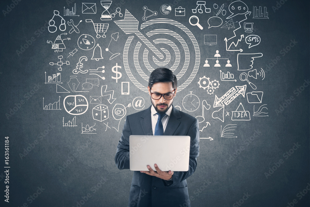 Businessman using laptop in front of icons Businessman using laptop in front of icons