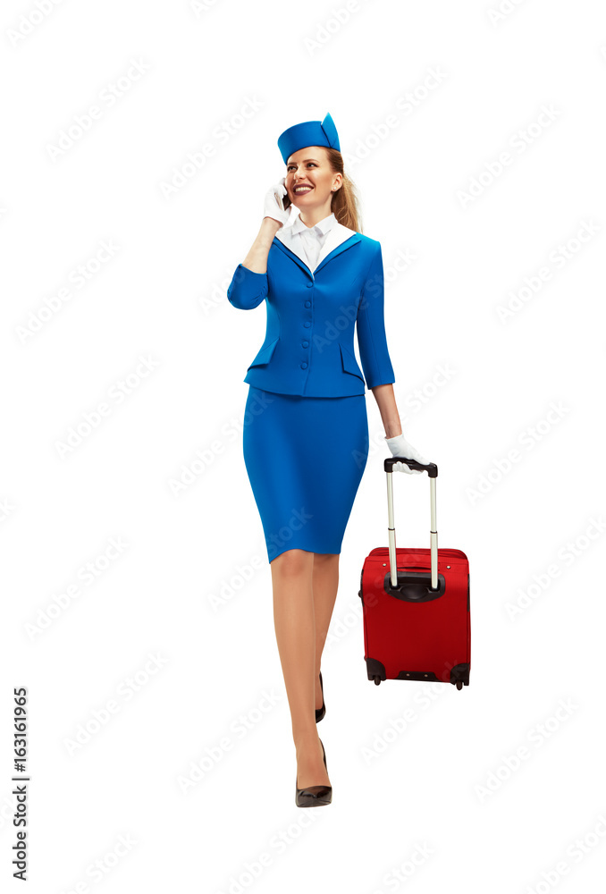 The stewardess walks and rolls her suitcase and speaks on the phone. The stewardess walks and rolls her suitcase and speaks on the phone.