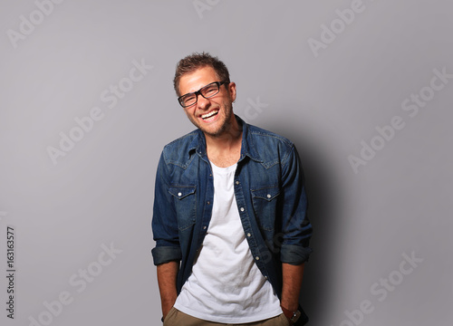 Young man in a denim shirt is smiling