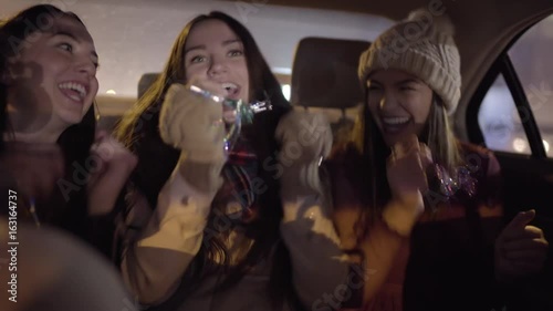 Group Of Friends Celebrate In Backseat Of Moving Car, They Make Up A Dance Move Together And Laugh